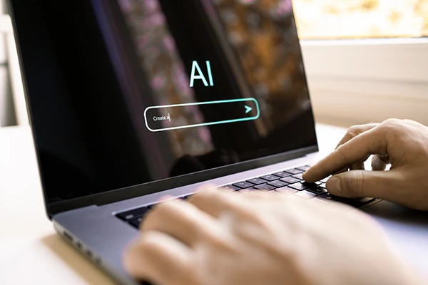Persona escribiendo en una laptop con una interfaz de IA generativa