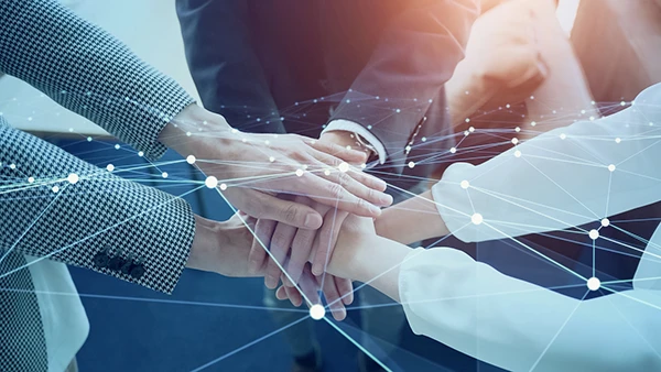 Equipo une las manos bajo una red de conexiones digitales superpuesta